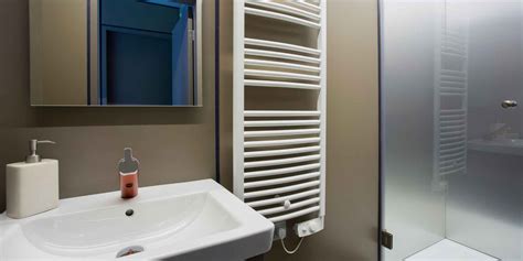 Intérieur de salle de bain avec un sèche-serviette raccordé via une sortie de câble