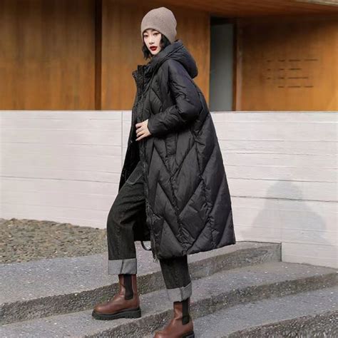 Une femme portant une doudoune longue oversize avec un jean boyfriend