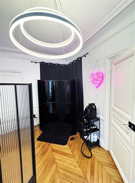 Femme recevant un spray tan dans une cabine professionnelle