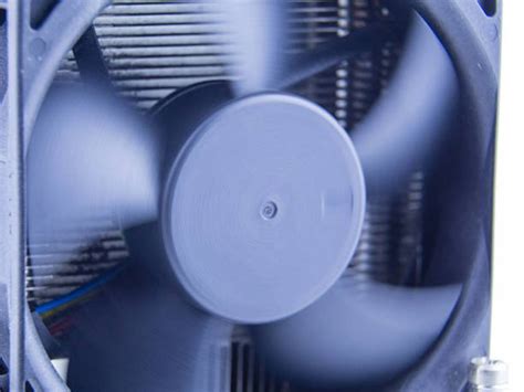Gros plan sur les pales d'un ventilateur anti-mouche avec des reflets argentés.