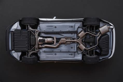 Vue du dessous d'une Peugeot 206 montrant l'emplacement du compresseur de climatisation