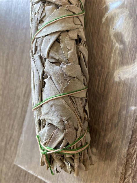 Bâton de sauge blanche fumant avec des volutes de fumée