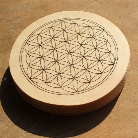 Symbole de la Fleur de Vie gravé sur un support en bois