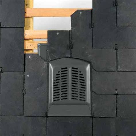 Vue rapprochée d'une chatière de ventilation intégrée dans une toiture en ardoise