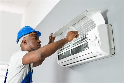 Un technicien répare une unité de climatisation.