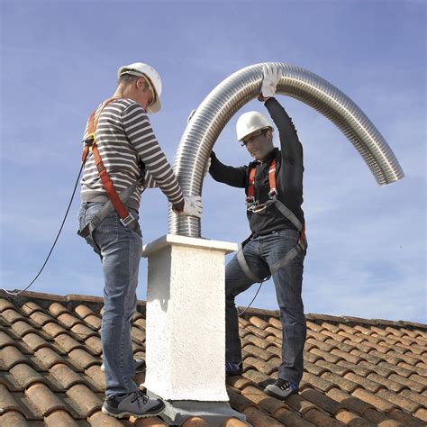 Chauffagiste effectuant un ramonage de conduit de cheminée