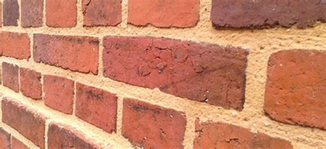 Photographie montrant des chantepleures sur un mur en brique ancien