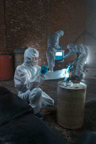 Professionnel en combinaison de protection inspectant un mur