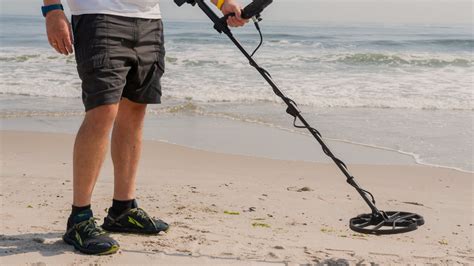 Plage avec un détecteur de métaux étanche