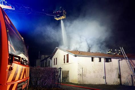 Maison en proie aux flammes et fumée s'élevant dans le ciel
