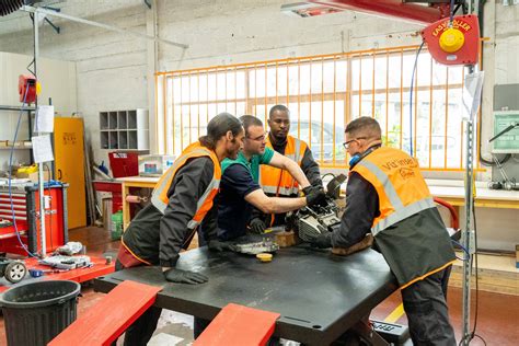 Intérieur d'un atelier de réparation de motos moderne avec des techniciens au travail