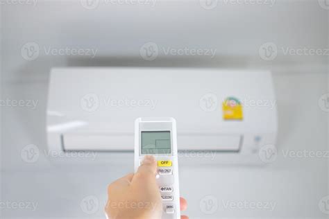 Image d'une main tenant une télécommande de climatiseur