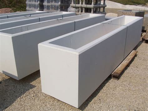 Jardinière en béton rectangulaire avec des plantes vertes