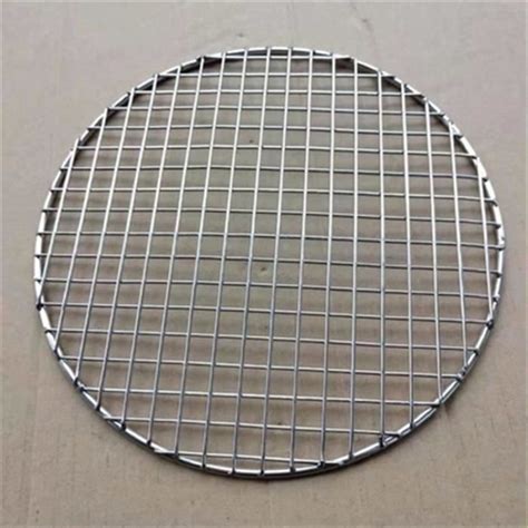 Détail de la grille ronde en acier inoxydable montrant la texture du métal